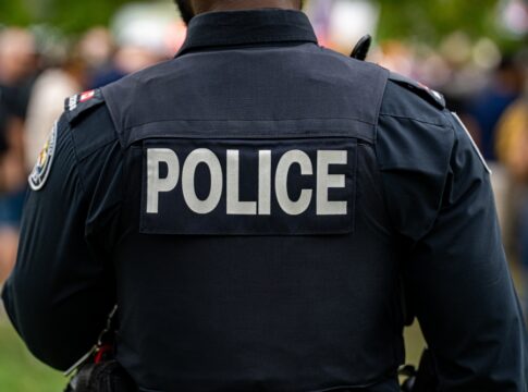 Back view of a police officer in uniform at a public event