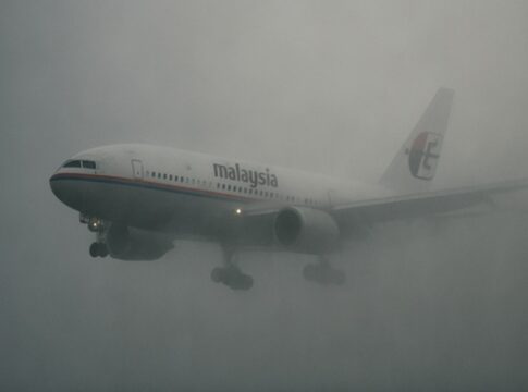 Airplane flying through thick fog over water