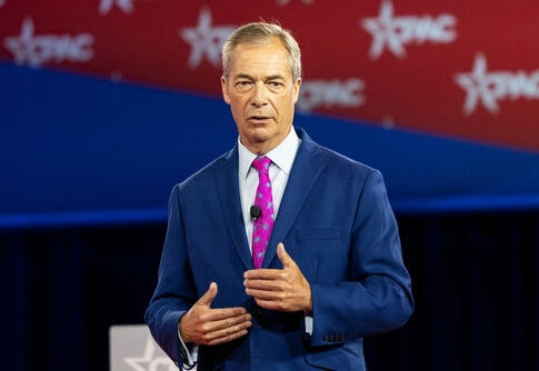 Man in a blue suit speaking on stage